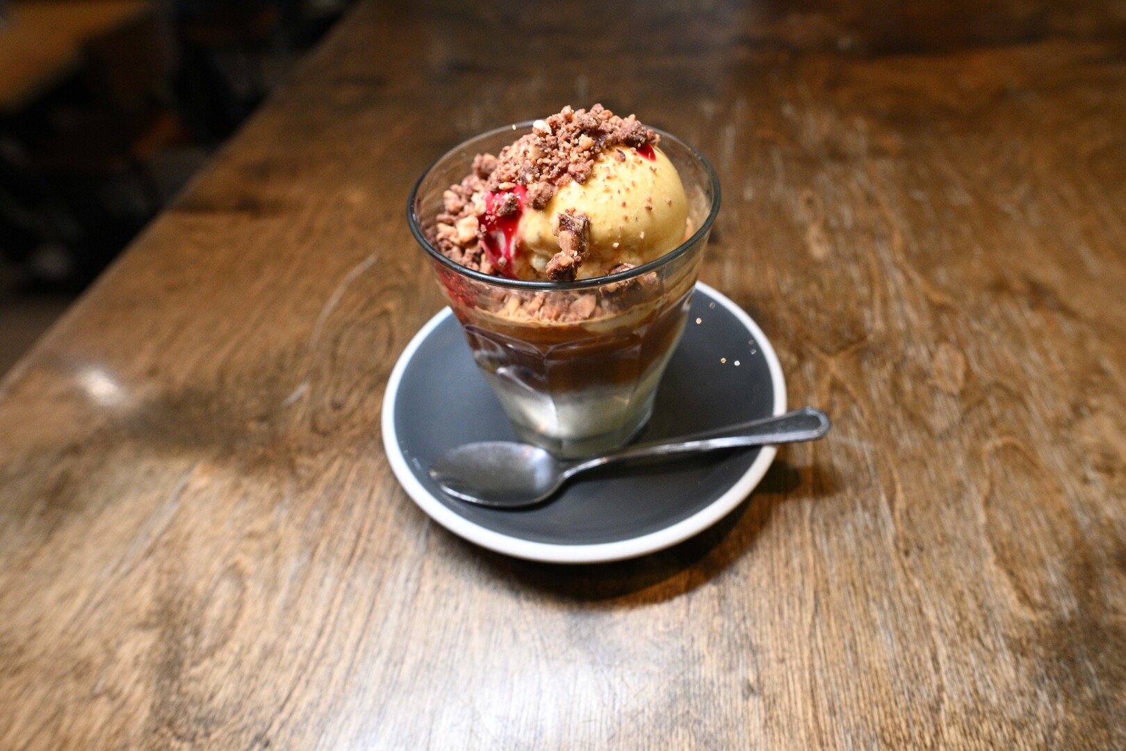 Affogato in a glass on a saucer.